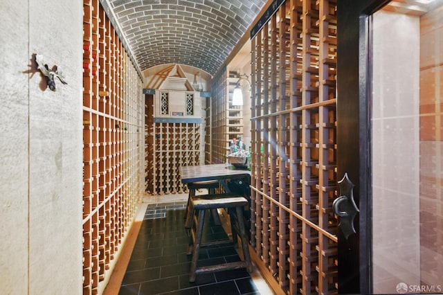 wine room with lofted ceiling and brick ceiling