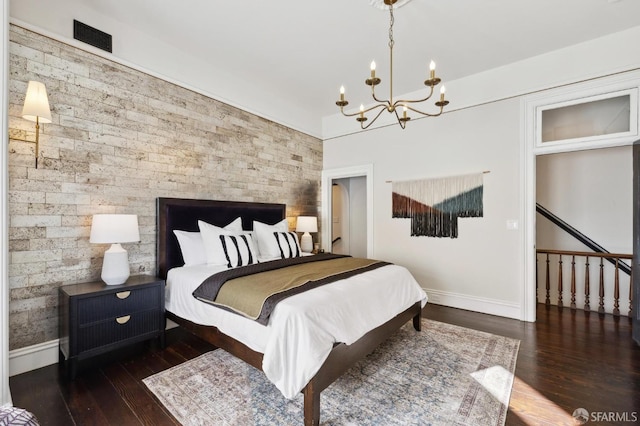 bedroom with dark wood-type flooring and a notable chandelier