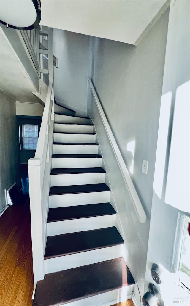 stairway with hardwood / wood-style floors