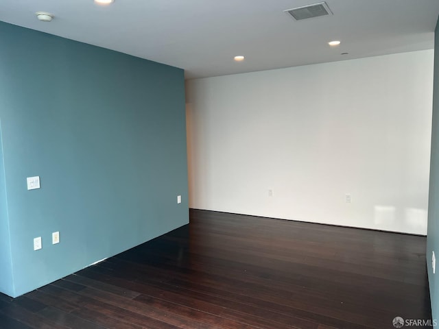 unfurnished room with dark wood-type flooring