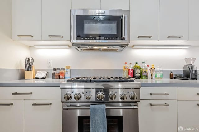 kitchen featuring stainless steel appliances, white cabinets, light countertops, and modern cabinets