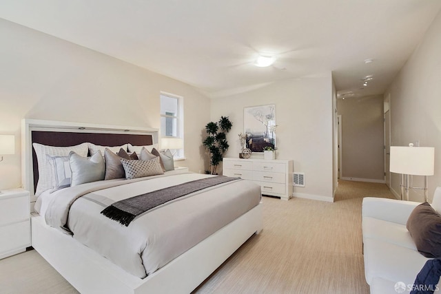 bedroom with light carpet and baseboards