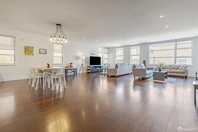 dining area featuring dark wood-type flooring, recessed lighting, baseboards, and a chandelier