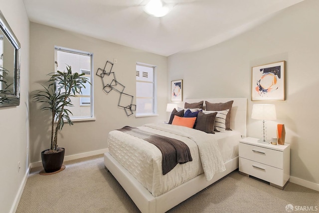 bedroom featuring light carpet and baseboards