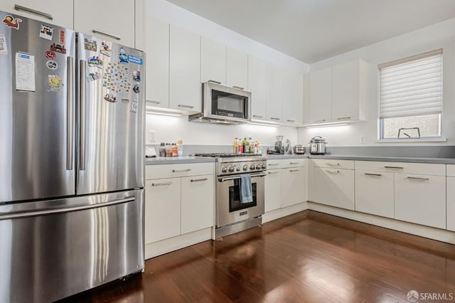 kitchen featuring appliances with stainless steel finishes, dark wood-type flooring, and white cabinets