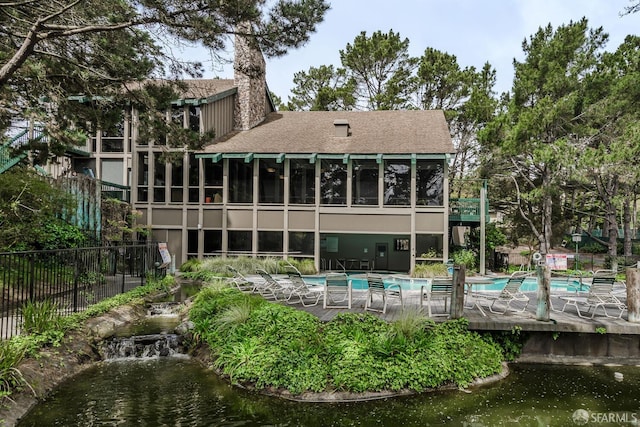 397 Imperial Way Unit 141, Daly City, CA 94015 - back of property with fence, a shingled roof, a community pool, a chimney, and a patio