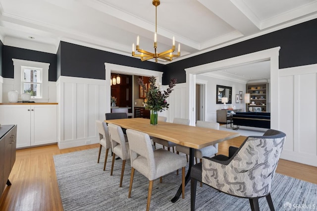 1123 Greenwich St, San Francisco, CA 94109 - dining room with a decorative wall, a chandelier, crown molding, light wood-style flooring, and a wainscoted wall