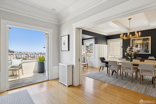 1123 Greenwich St, San Francisco, CA 94109 - dining space featuring a chandelier, a decorative wall, light wood finished floors, crown molding, and a wainscoted wall