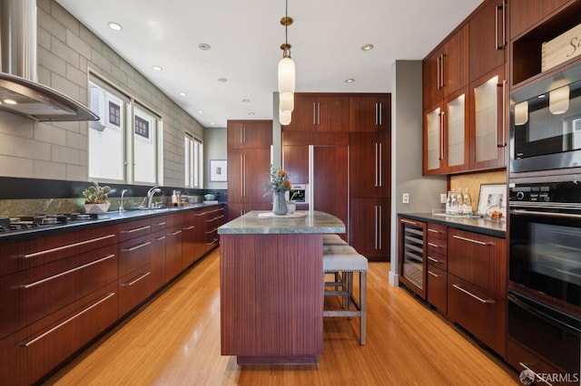 1123 Greenwich St, San Francisco, CA 94109 - kitchen with wall chimney range hood, a warming drawer, wine cooler, modern cabinets, and dark countertops