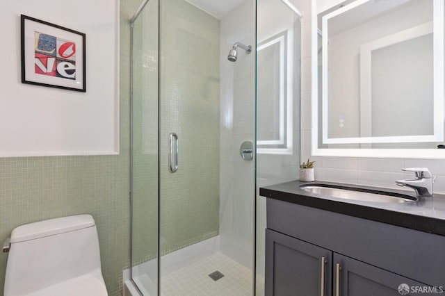 bathroom featuring vanity, tile walls, toilet, and an enclosed shower