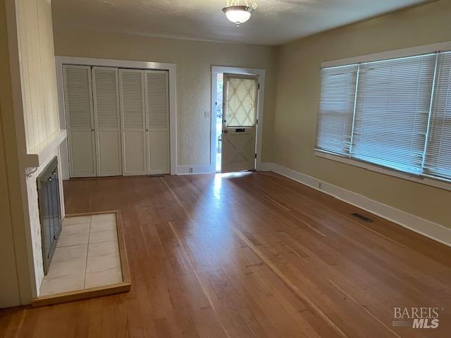 interior space with a tiled fireplace and light hardwood / wood-style floors