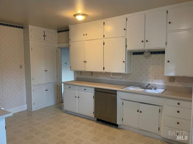 kitchen with sink, stainless steel dishwasher, and white cabinets