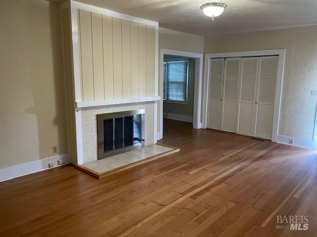 unfurnished living room featuring hardwood / wood-style flooring and a fireplace