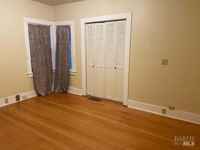 unfurnished bedroom with wood-type flooring