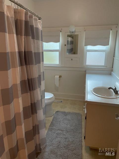 bathroom featuring vanity, tile patterned flooring, and toilet