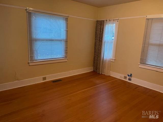 unfurnished room with hardwood / wood-style floors