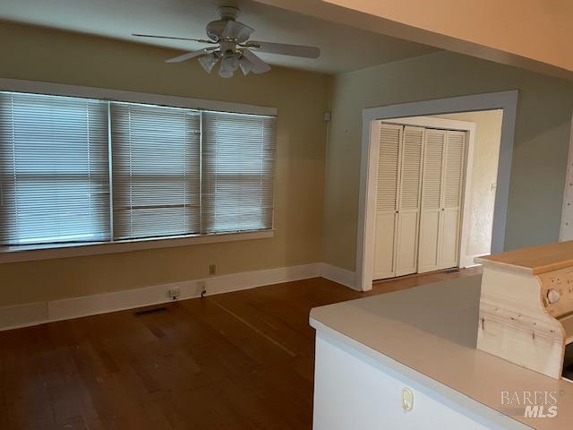 unfurnished dining area featuring ceiling fan and dark hardwood / wood-style flooring