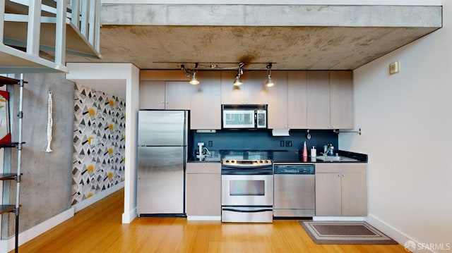 kitchen with light hardwood / wood-style floors, appliances with stainless steel finishes, and sink