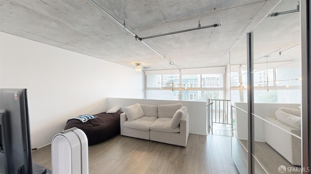 living room with wood-type flooring and floor to ceiling windows