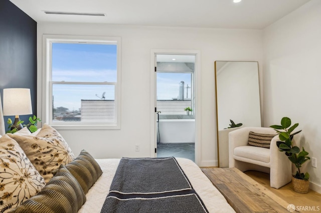 bedroom with hardwood / wood-style flooring and ensuite bath