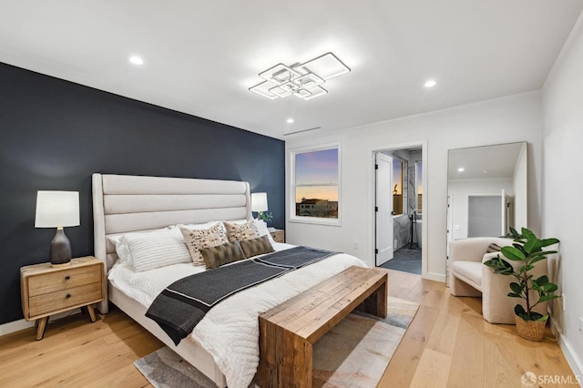 bedroom with recessed lighting, light wood-style flooring, baseboards, and a spacious closet