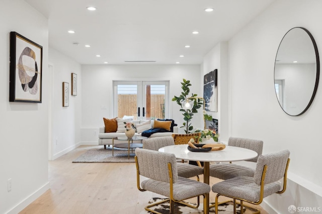 dining room featuring french doors and light wood-type flooring