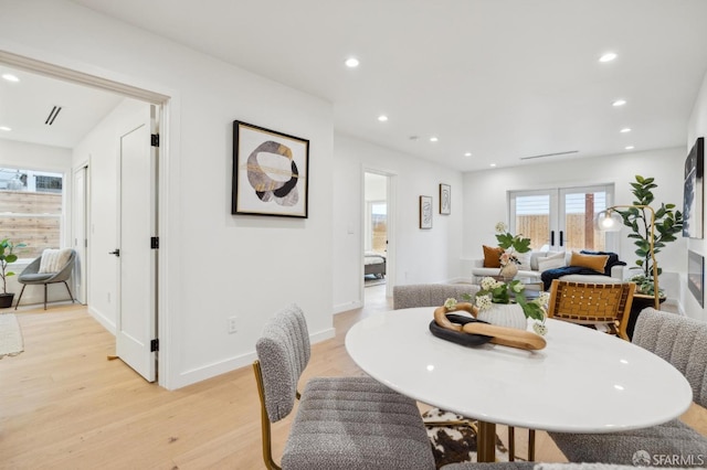 dining room featuring french doors and light hardwood / wood-style flooring