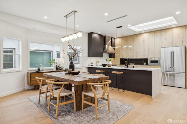 dining room with sink and light hardwood / wood-style flooring