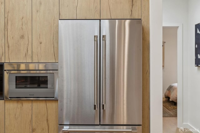 kitchen featuring appliances with stainless steel finishes and light brown cabinetry