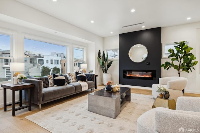 living room with a fireplace and light wood-type flooring