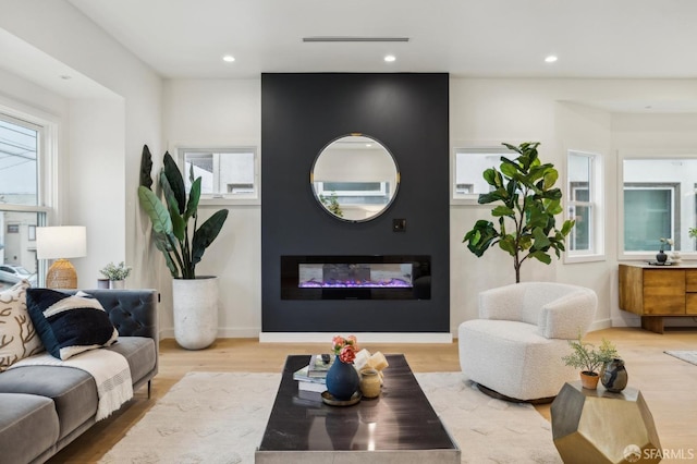 living room featuring wood-type flooring, plenty of natural light, and a fireplace