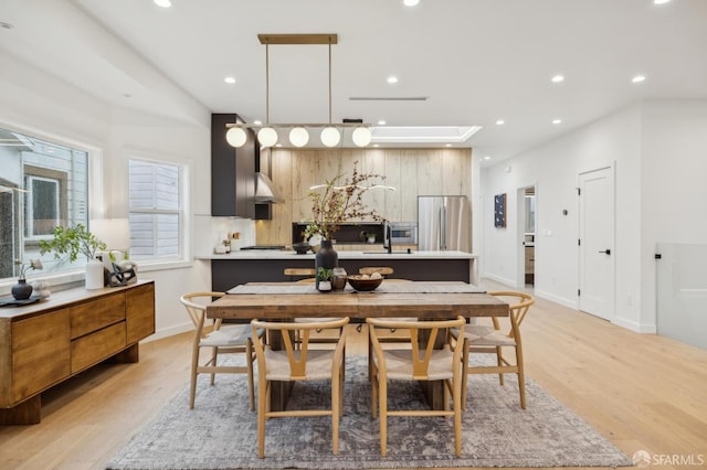 dining space with sink and light wood-type flooring