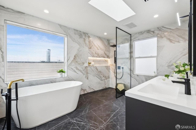 bathroom featuring vanity, shower with separate bathtub, and a skylight