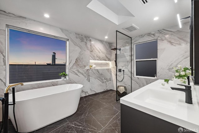 full bathroom with stone wall, a marble finish shower, marble finish floor, and a soaking tub