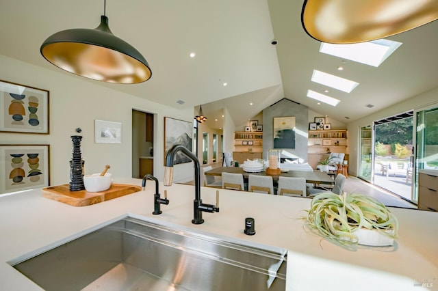 kitchen featuring sink, decorative light fixtures, built in features, and lofted ceiling with skylight