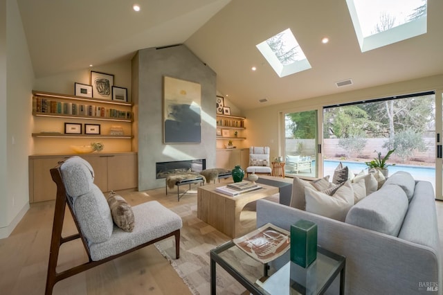 living room featuring high vaulted ceiling, a fireplace, and a skylight