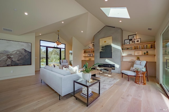 living room featuring vaulted ceiling with skylight and light hardwood / wood-style flooring