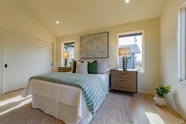 bedroom featuring lofted ceiling and light hardwood / wood-style flooring