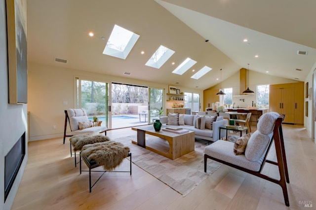 living room featuring high vaulted ceiling and light hardwood / wood-style flooring