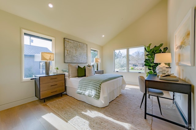 bedroom with lofted ceiling and light wood-type flooring