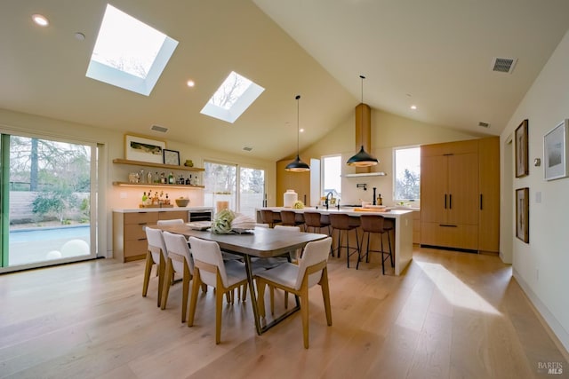 dining area with lofted ceiling, a healthy amount of sunlight, and light wood-type flooring