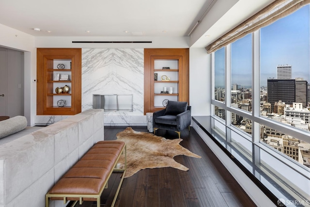 living room featuring built in shelves and dark hardwood / wood-style flooring