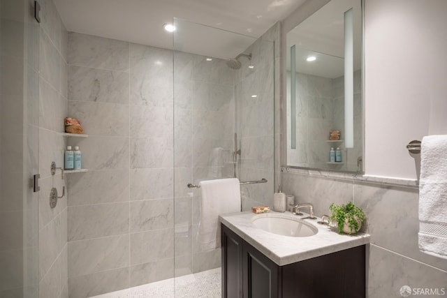 bathroom featuring vanity, tile walls, and tiled shower