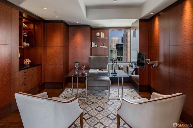 office space featuring hardwood / wood-style floors, built in shelves, and wooden walls