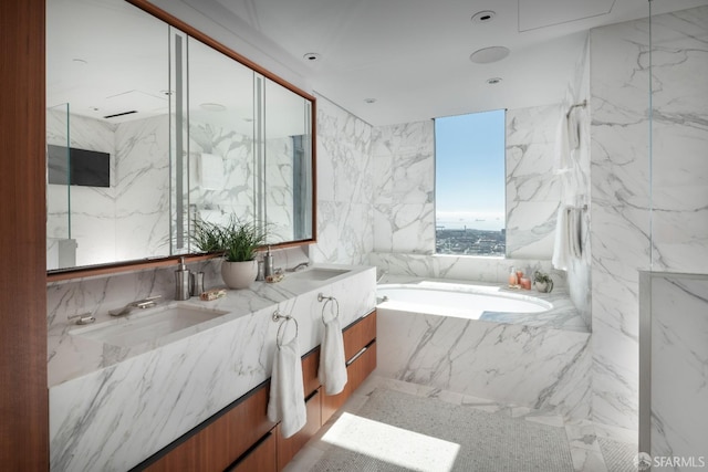 bathroom featuring vanity, tile walls, and tiled tub