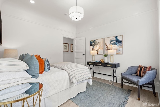 bedroom featuring baseboards and wood finished floors