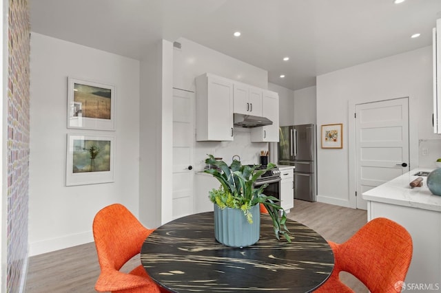 dining room featuring recessed lighting, baseboards, and light wood-type flooring