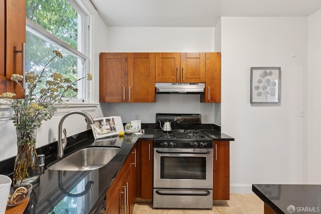 1250 Vallejo St Unit 7, San Francisco, CA 94109 - kitchen featuring stainless steel range with gas cooktop, under cabinet range hood, dark stone countertops, and brown cabinets