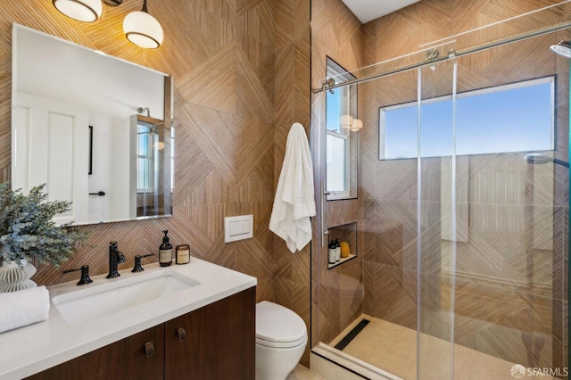 bathroom featuring vanity, toilet, tile walls, and plenty of natural light