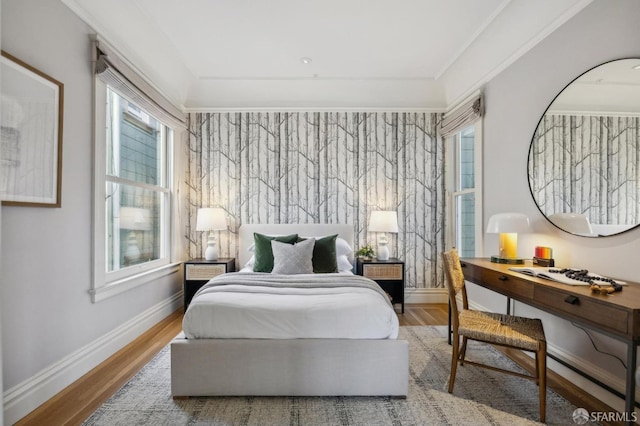 bedroom with ornamental molding and light hardwood / wood-style floors